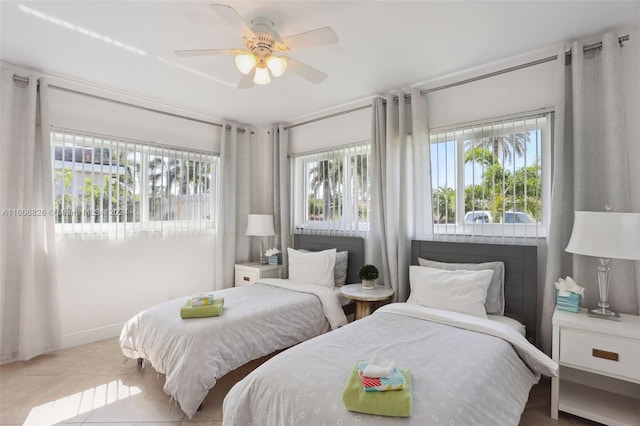 bedroom with ceiling fan, light tile patterned flooring, and multiple windows