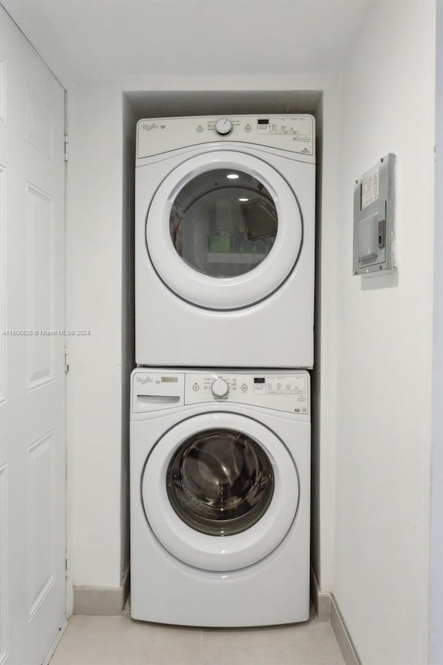 laundry area featuring stacked washer and dryer and light tile patterned floors