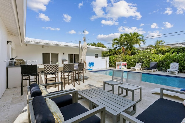 view of swimming pool with a patio and exterior bar