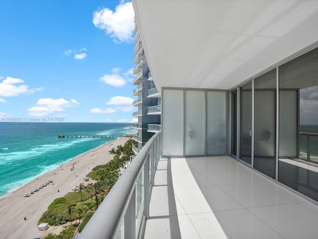 balcony featuring a view of the beach and a water view