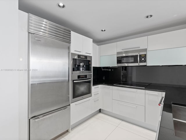 kitchen with white cabinetry, light tile patterned floors, and stainless steel appliances