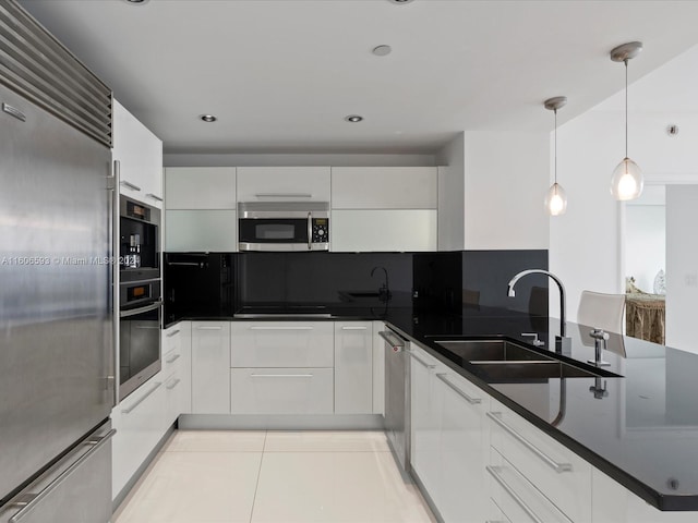 kitchen featuring white cabinetry, sink, stainless steel appliances, pendant lighting, and light tile patterned floors