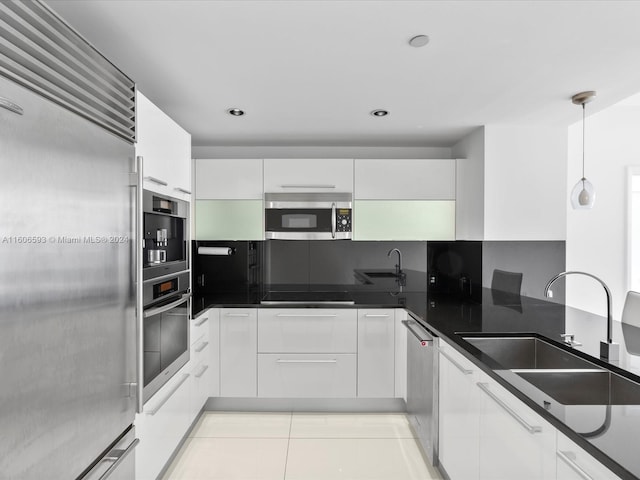 kitchen with white cabinets, pendant lighting, sink, and appliances with stainless steel finishes