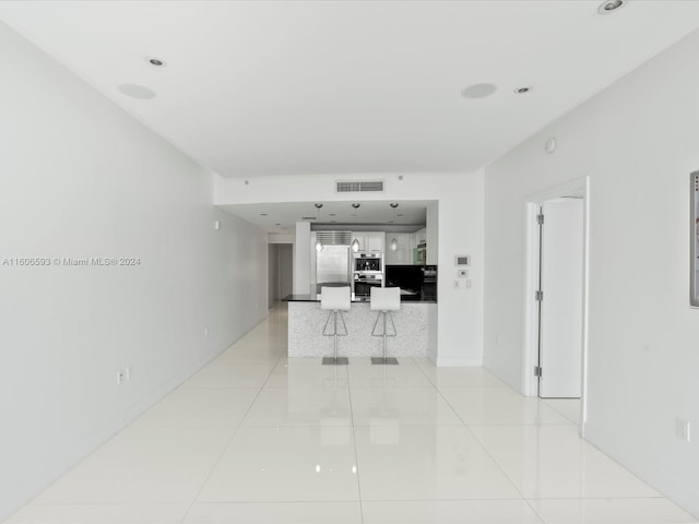 hall with light tile patterned floors