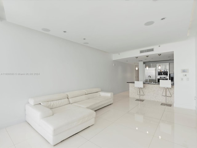 living room with light tile patterned flooring and sink