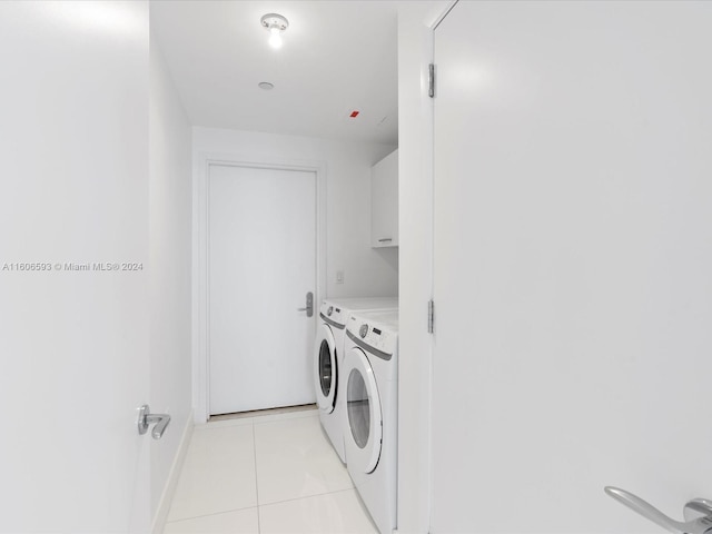 washroom featuring cabinets, independent washer and dryer, and light tile patterned floors