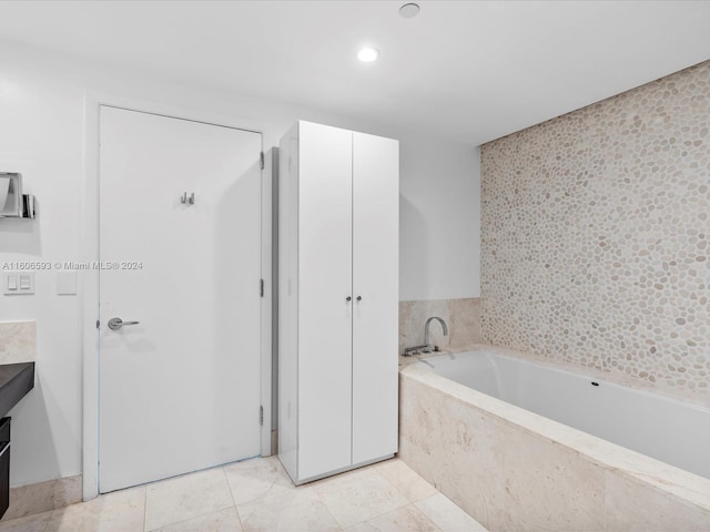 bathroom featuring vanity, tiled bath, and tile patterned floors