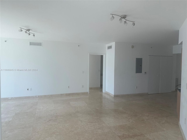 unfurnished room with rail lighting, electric panel, and visible vents