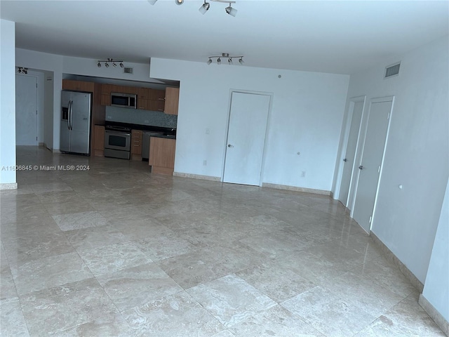 unfurnished living room with track lighting and light tile floors