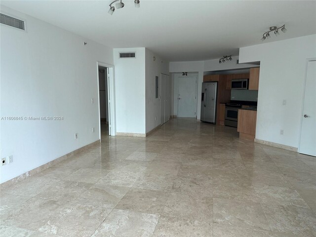 interior space featuring track lighting and light tile flooring