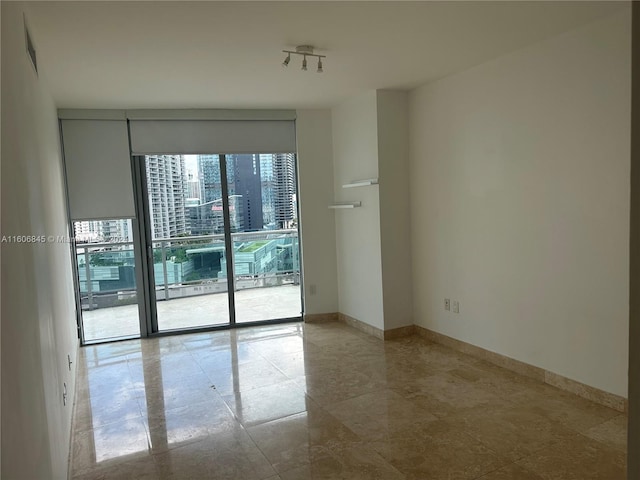 empty room with tile flooring and track lighting