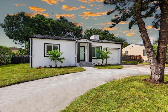 mediterranean / spanish-style house featuring a yard and a garage