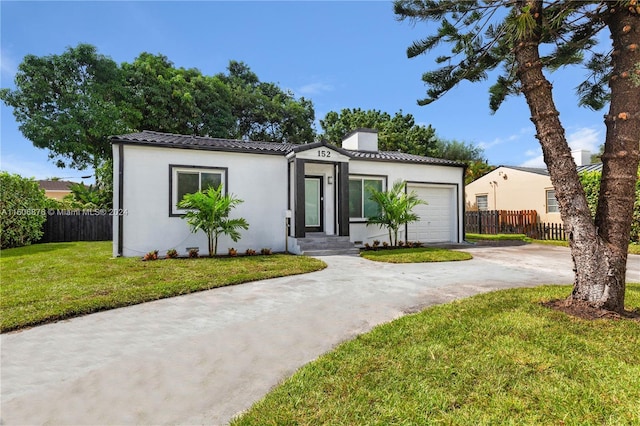 view of front of home with a garage and a front lawn