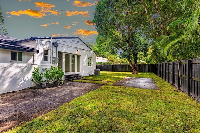 yard at dusk featuring a patio area and cooling unit