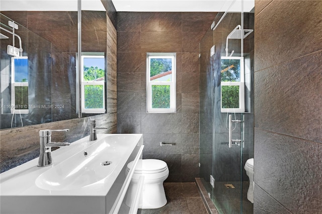 bathroom with tile walls, toilet, and plenty of natural light