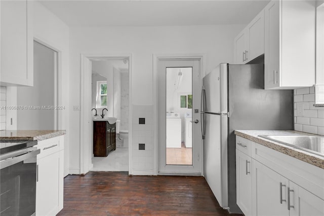 kitchen with white cabinets, washer / dryer, plenty of natural light, and dark hardwood / wood-style floors