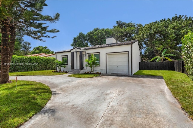 mediterranean / spanish-style house featuring a front yard and a garage