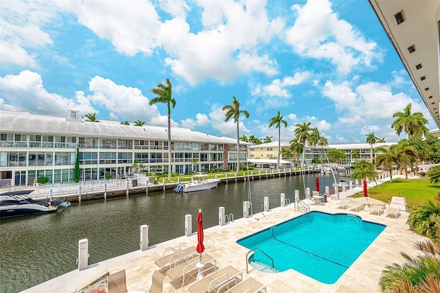 view of pool featuring a water view and a patio