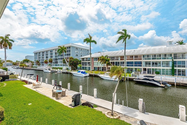 dock area featuring a lawn, a patio area, and a water view