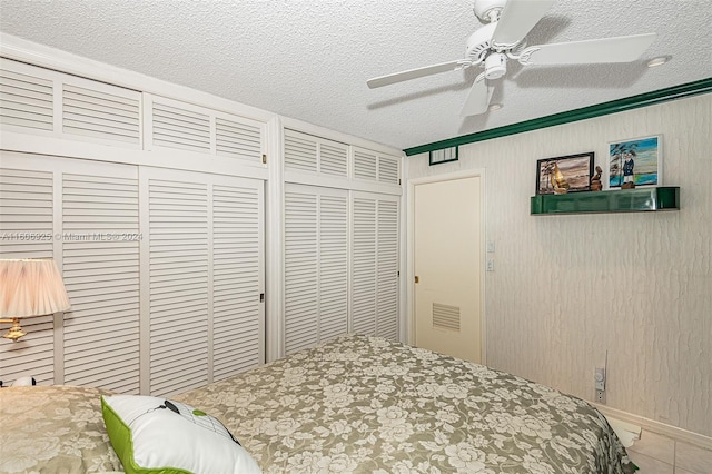 bedroom featuring ceiling fan, ornamental molding, a textured ceiling, and a closet