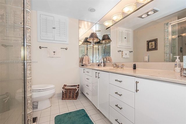 bathroom with tile patterned flooring, vanity, toilet, and an enclosed shower