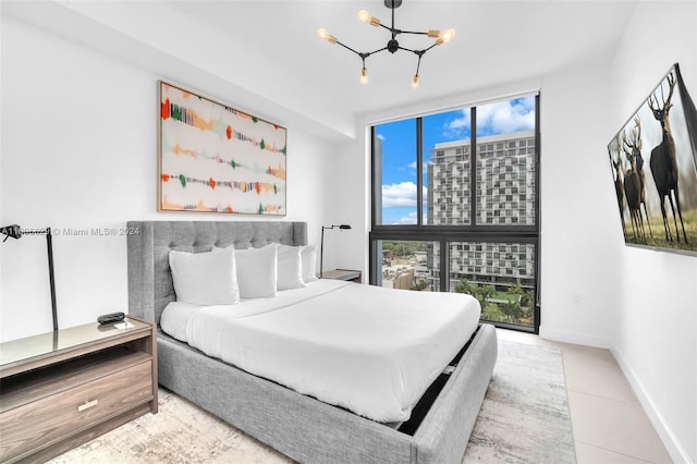 tiled bedroom featuring floor to ceiling windows and an inviting chandelier