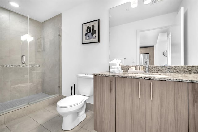 bathroom with tile patterned floors, walk in shower, vanity, and toilet