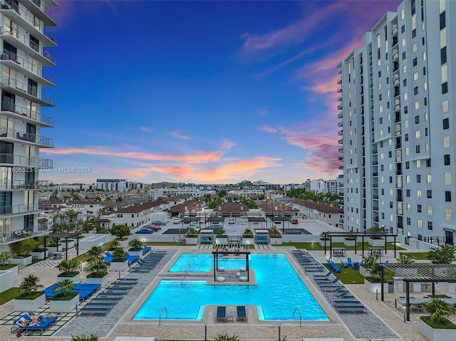 pool at dusk with a patio area