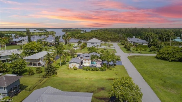 aerial view at dusk featuring a water view