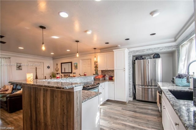 kitchen featuring white cabinetry, light stone countertops, stainless steel fridge, hardwood / wood-style flooring, and pendant lighting