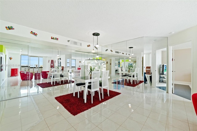 dining space featuring a textured ceiling and light tile floors