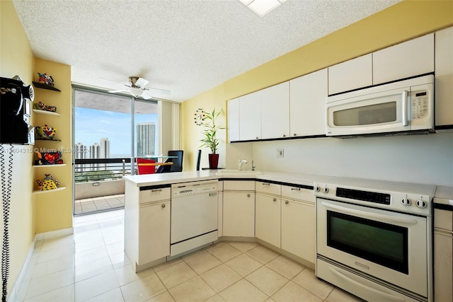 kitchen with ceiling fan, kitchen peninsula, white appliances, a textured ceiling, and floor to ceiling windows