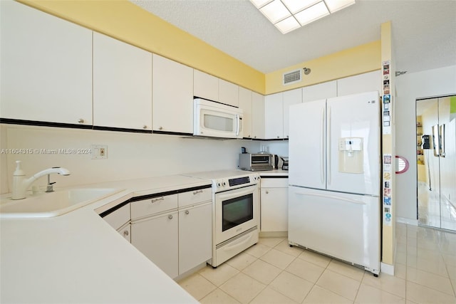 kitchen featuring sink, white cabinetry, white appliances, and light tile floors