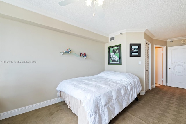 carpeted bedroom featuring ornamental molding, ceiling fan, and a textured ceiling