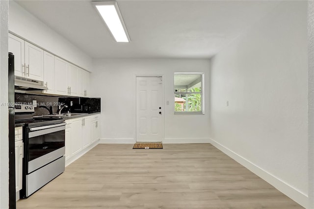 kitchen with sink, light hardwood / wood-style floors, white cabinets, stainless steel range with electric cooktop, and tasteful backsplash