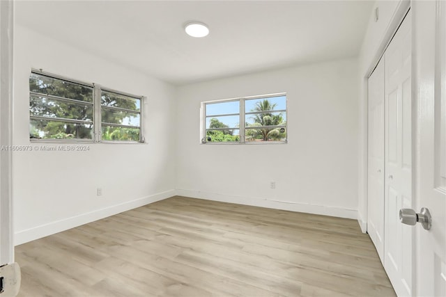 unfurnished bedroom with a closet and light hardwood / wood-style floors