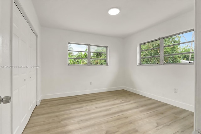 unfurnished bedroom with light wood-type flooring and a closet