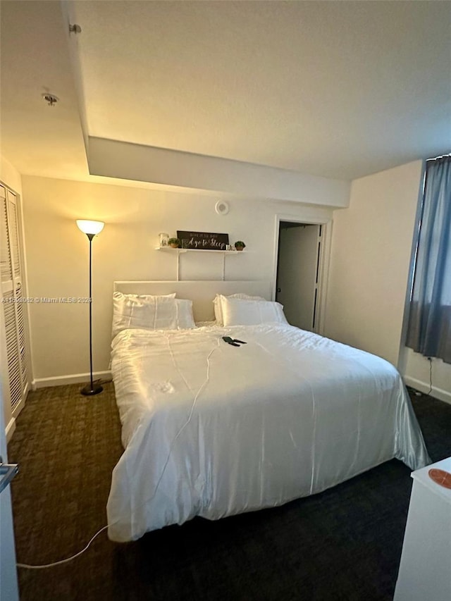 bedroom featuring a closet and dark carpet