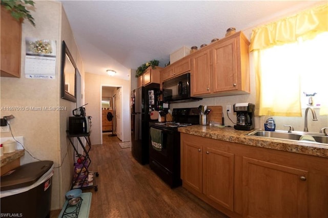 kitchen featuring vaulted ceiling, sink, black appliances, and dark hardwood / wood-style floors