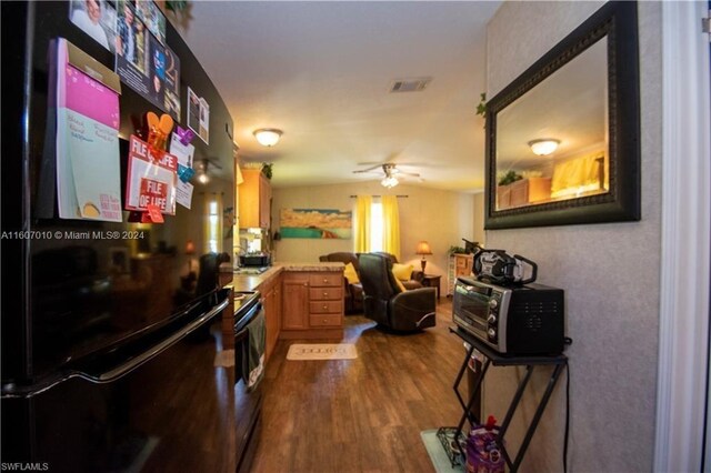 kitchen with black fridge, range with electric cooktop, ceiling fan, and dark hardwood / wood-style flooring