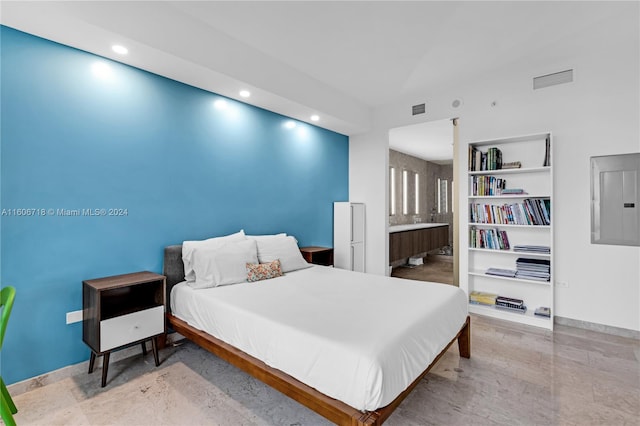 bedroom with hardwood / wood-style floors and ensuite bathroom