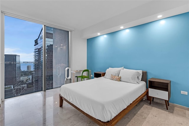 bedroom featuring floor to ceiling windows and light tile floors