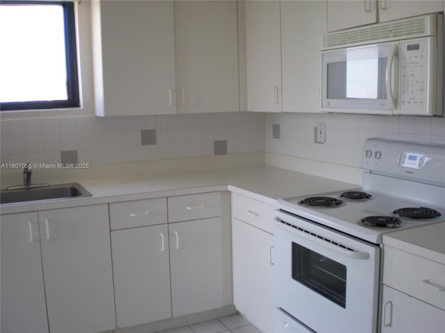 kitchen with white appliances, white cabinetry, sink, and decorative backsplash