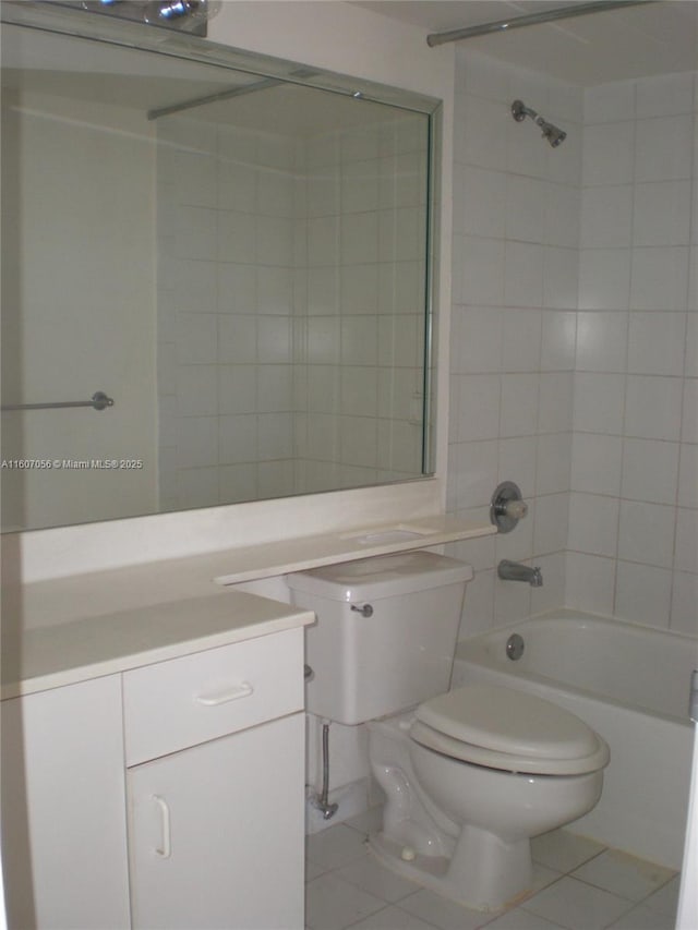 full bathroom featuring tiled shower / bath combo, tile patterned floors, vanity, and toilet