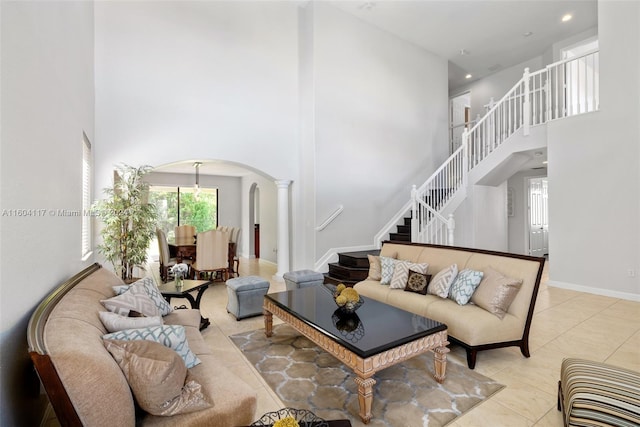 tiled living room featuring ornate columns and a high ceiling