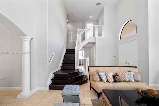 living room with a high ceiling and light tile patterned floors