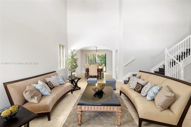 living room with decorative columns and a high ceiling