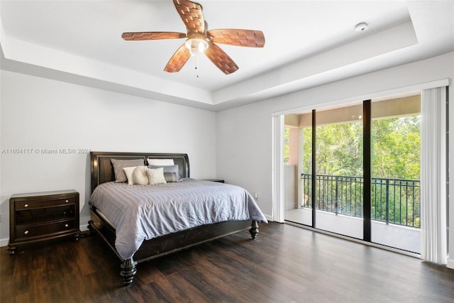 bedroom with dark hardwood / wood-style floors, ceiling fan, access to exterior, and a tray ceiling