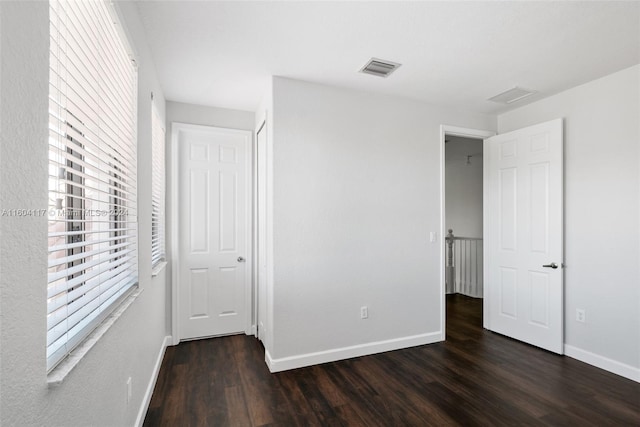 unfurnished bedroom featuring dark hardwood / wood-style flooring