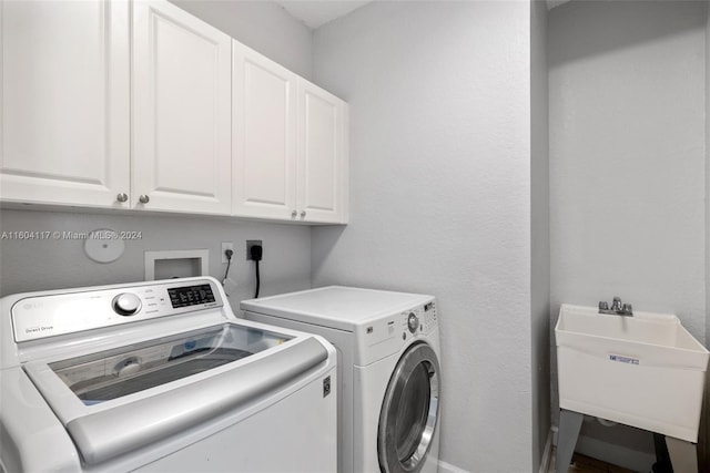 laundry room with cabinets, sink, and washer and dryer